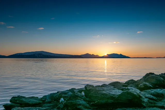 Die Mitternachtssonne über der Insel Reinøya im Ullsfjord in Norwegen